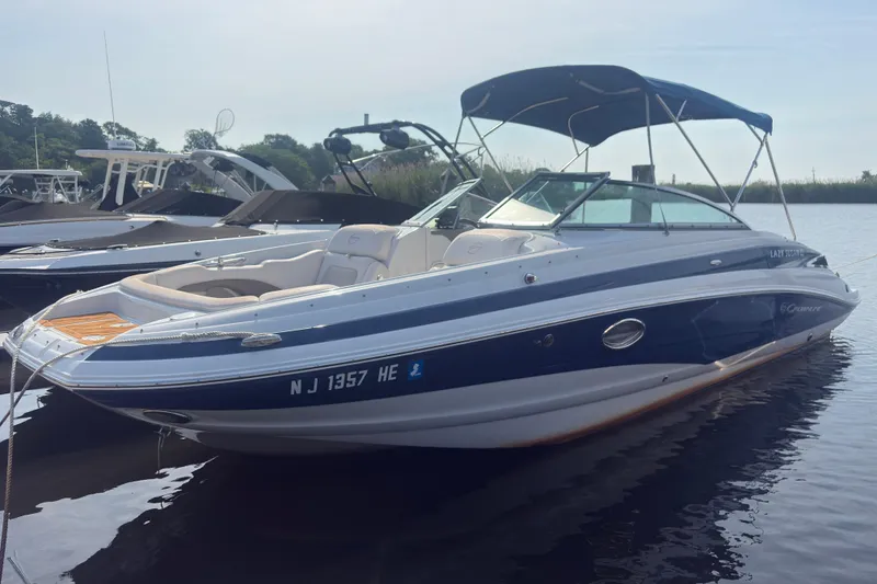The Image of 2013 Crownline Eclipse E6 boat docked on calm water with canopy. - 0