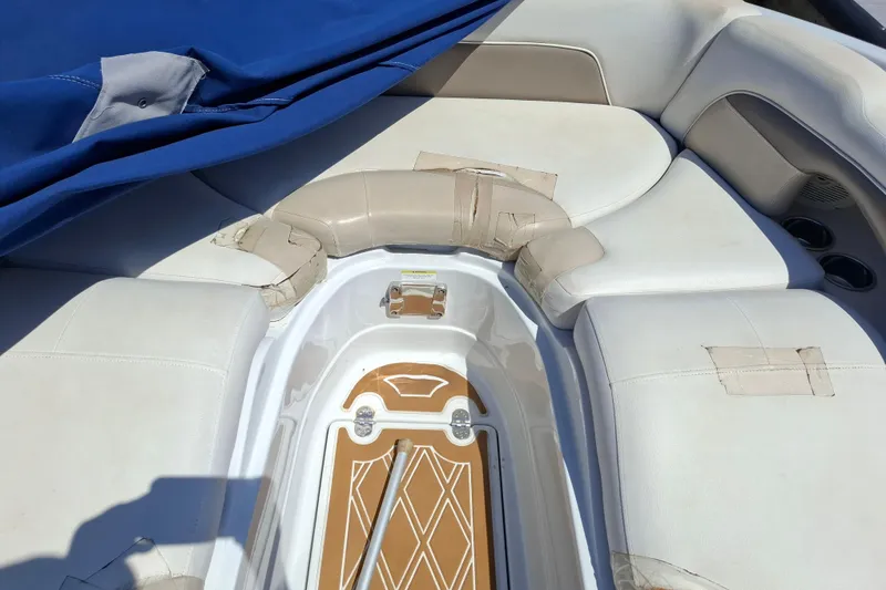 Slide: The Image of Interior of a 2013 Crownline Eclipse E6 boat with white seating and blue cover. - 9