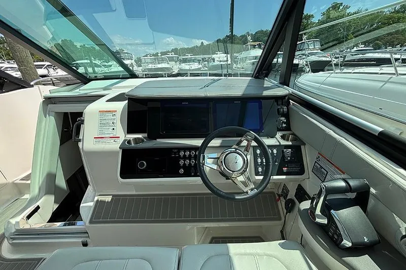 Slide: The Image of 2024 Sea Ray Sundancer 320 Outboard helm with modern controls and navigation displays. - 30