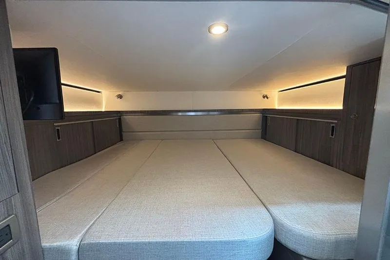 Slide: The Image of 2024 Sea Ray Sundancer 320 Outboard cabin interior with cozy bed and ambient lighting. - 36