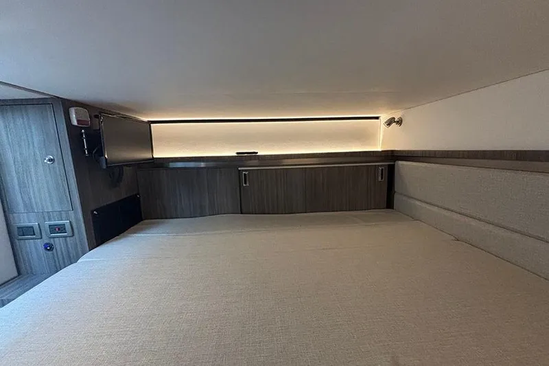 Slide: The Image of 2024 Sea Ray Sundancer 320 Outboard cabin interior with modern wood finish and ambient lighting. - 38
