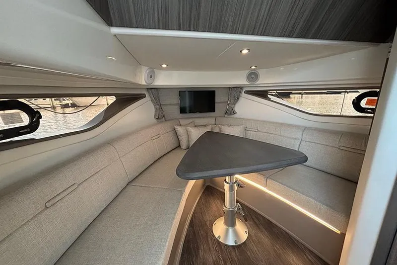 Slide: The Image of 2024 Sea Ray Sundancer 320 Outboard cabin interior with modern seating and table. - 32