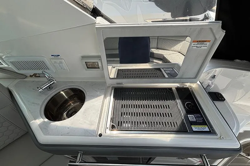 Slide: The Image of 2024 Sea Ray Sundancer 320 Outboard boat kitchenette with sink and grill. - 25