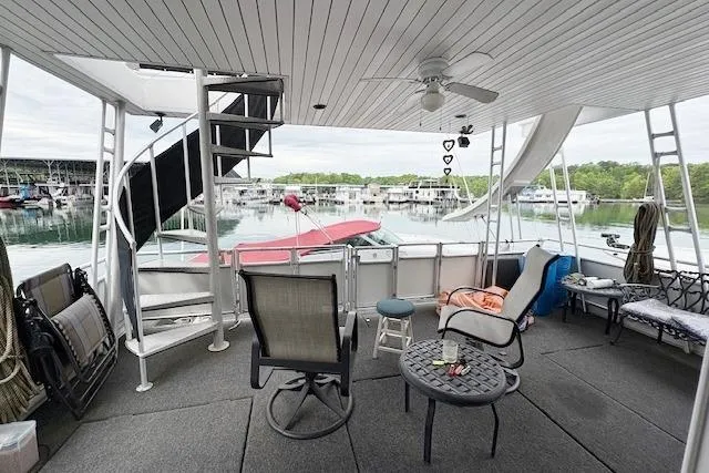 Slide: The Image of Spacious deck of 2007 Sumerset 18x86 houseboat with seating, spiral staircase, and waterfront view. - 14