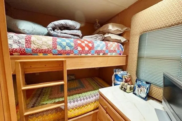 Slide: The Image of Bunk beds with colorful quilts in a 2007 Sumerset 18x86 houseboat interior. - 8