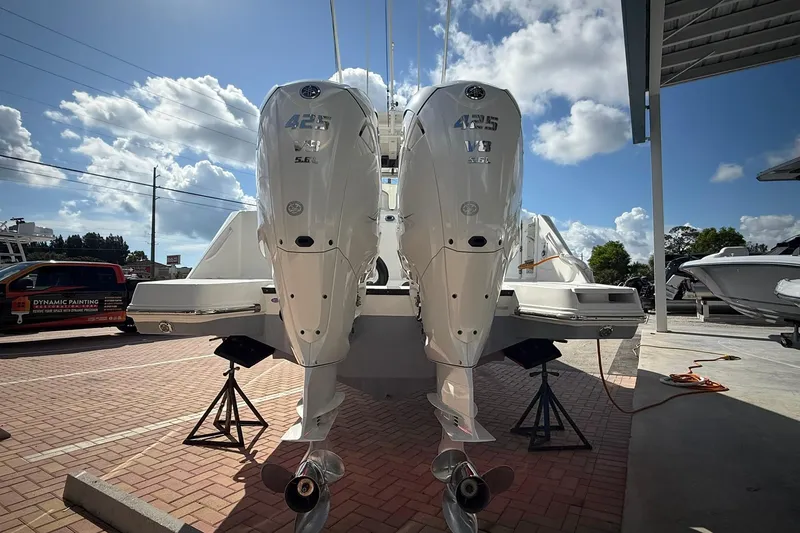 Slide: The Image of 2022 Edgewater 340CC boat with twin 425 V8 engines, parked outdoors under a clear sky. - 4