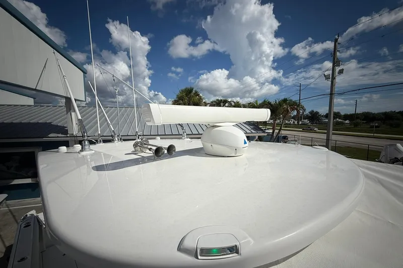Slide: The Image of 2022 Edgewater 340CC boat roof with radar and antennas under a blue sky. - 51