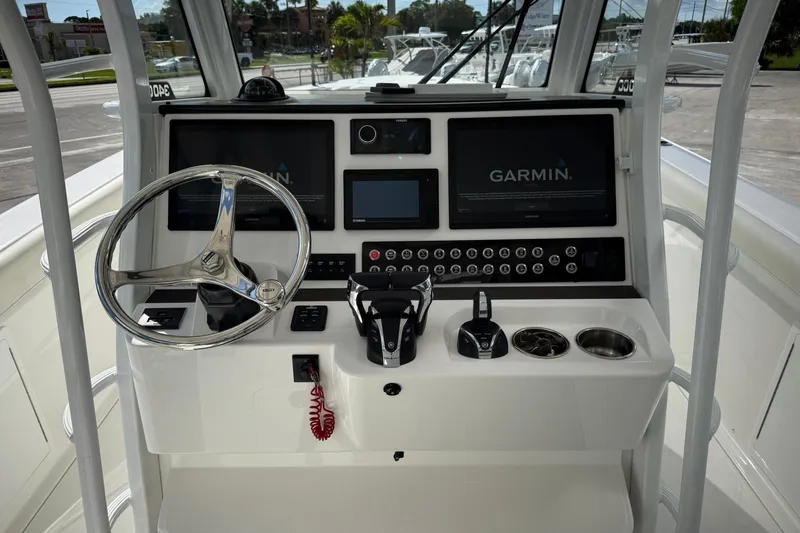 Slide: The Image of 2022 Edgewater 340CC boat dashboard with Garmin navigation displays and steering wheel. - 28