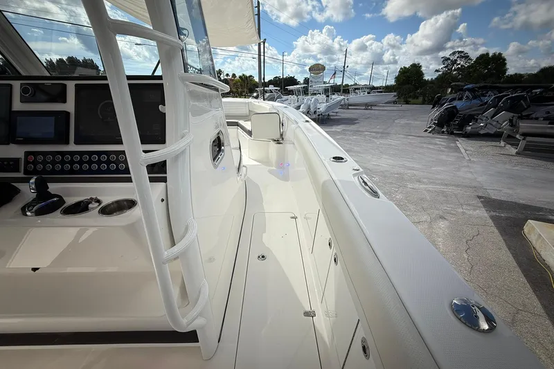 Slide: The Image of 2022 Edgewater 340CC boat interior with control panel and seating, under a partly cloudy sky. - 38