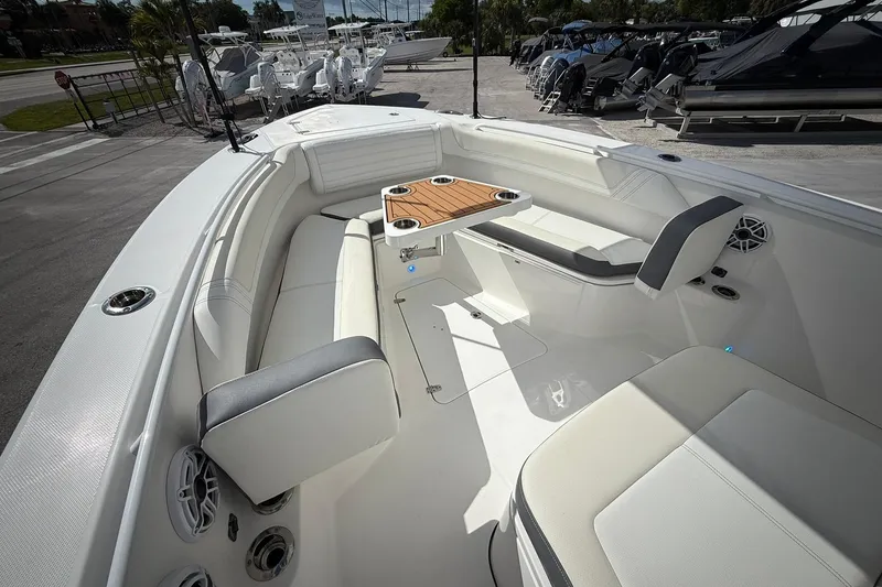 Slide: The Image of 2022 Edgewater 340CC boat interior with seating and table, docked outdoors. - 43
