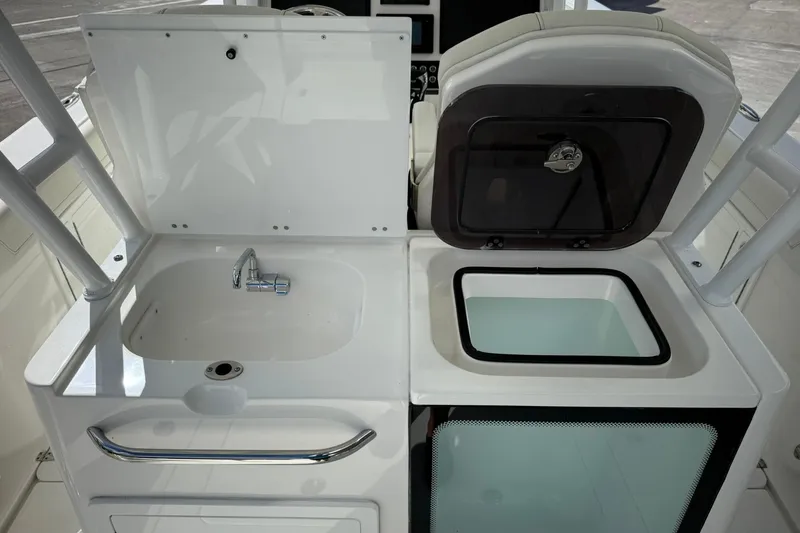 Slide: The Image of 2022 Edgewater 340CC boat interior with sink and storage compartment. - 12