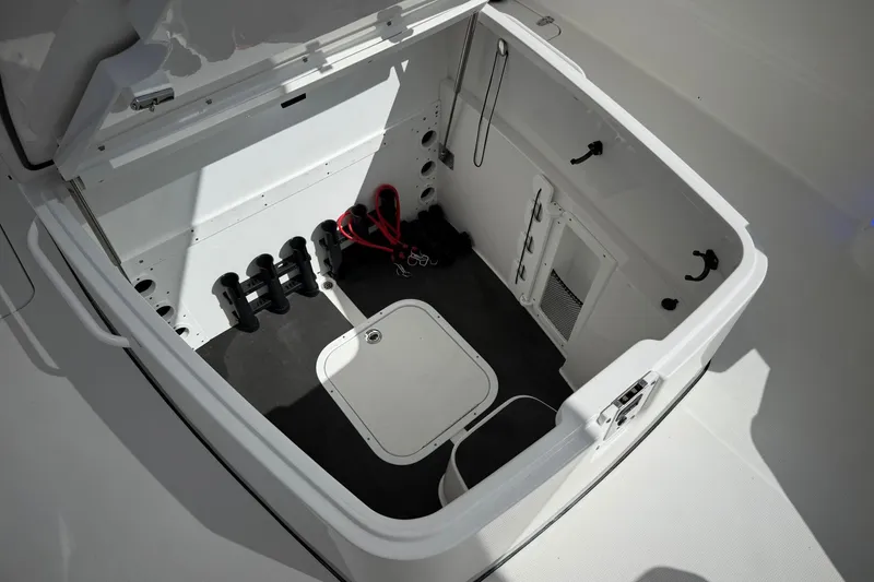 Slide: The Image of 2022 Edgewater 340CC boat storage compartment with organized interior and safety equipment. - 49