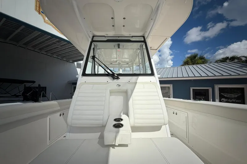 Slide: The Image of 2022 Edgewater 340CC boat interior with white seating and windshield under a blue sky. - 50