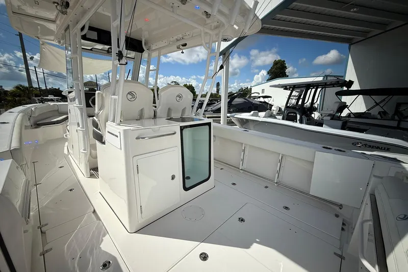 Slide: The Image of 2022 Edgewater 340CC boat interior showcasing seating and storage under a covered area. - 21
