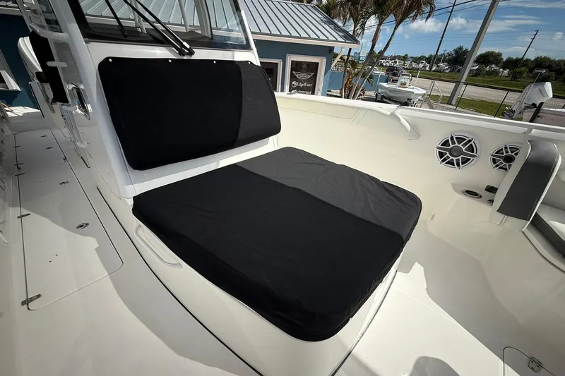 Slide: The Image of 2022 Edgewater 340CC boat interior with black cushioned seating and speakers. - 47
