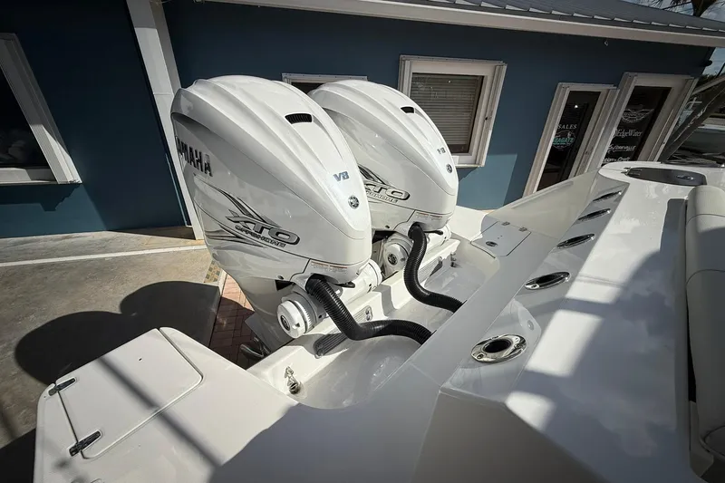Slide: The Image of 2022 Edgewater 340CC boat with dual Yamaha V8 outboard engines, docked near a blue building. - 5
