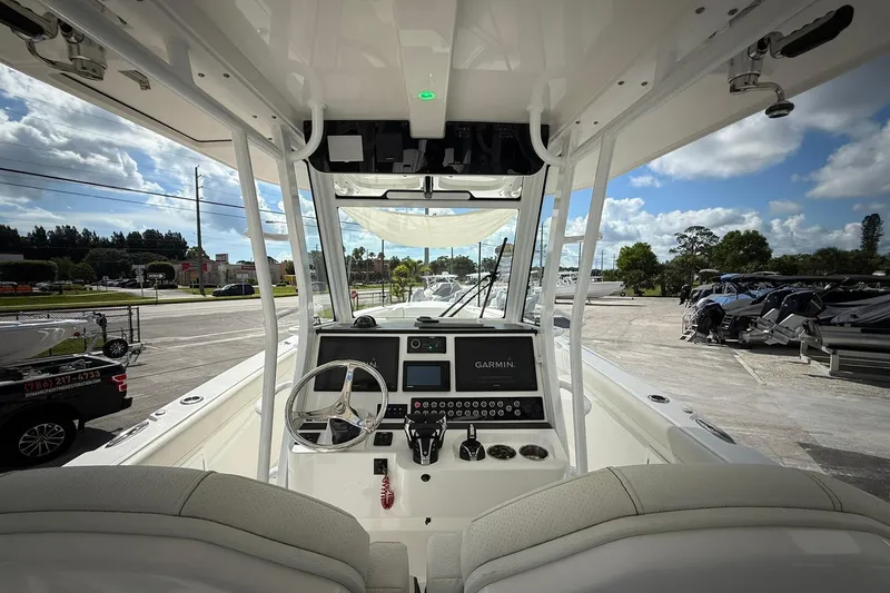 Slide: The Image of 2022 Edgewater 340CC boat cockpit with Garmin navigation, parked outdoors under a blue sky. - 25