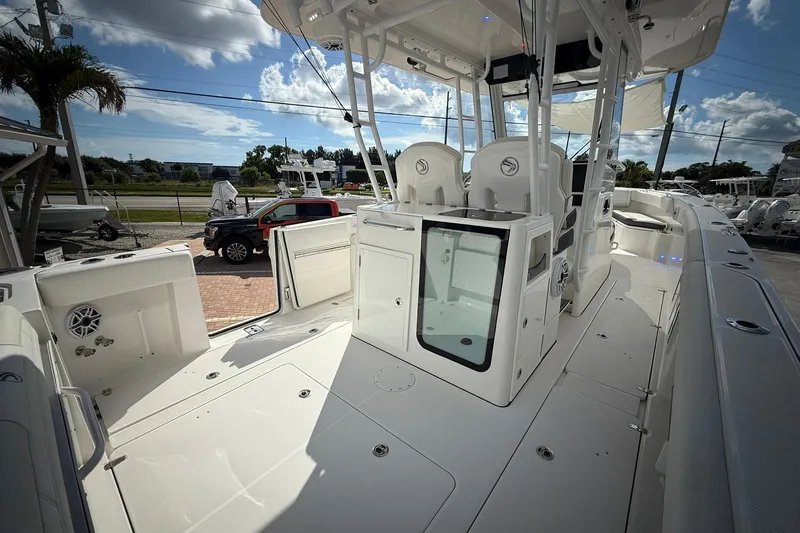 Slide: The Image of 2022 Edgewater 340CC boat interior with seating and storage, under a sunny sky. - 19