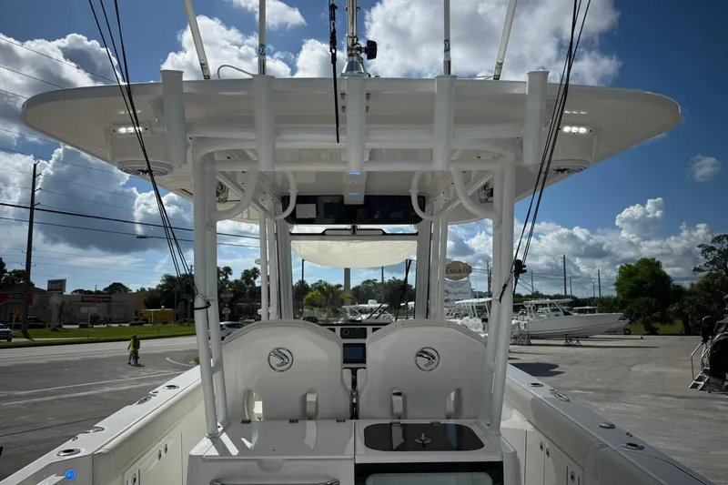 Slide: The Image of 2022 Edgewater 340CC boat with T-top, docked under a partly cloudy sky. - 9