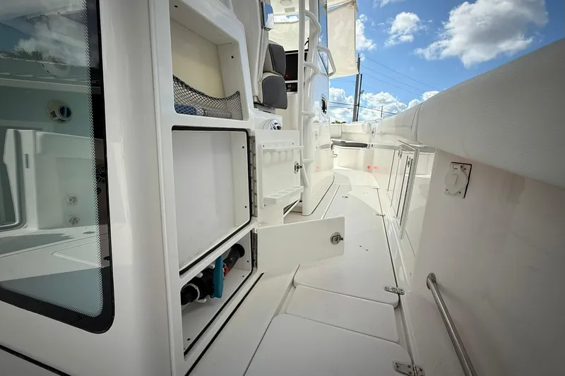 Slide: The Image of 2022 Edgewater 340CC boat interior with storage compartments and sleek white design. - 24