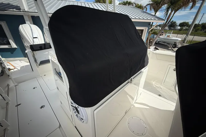 Slide: The Image of 2022 Edgewater 340CC boat interior with covered console, white deck, and outdoor setting. - 32