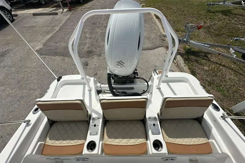 Slide: The Image of 2024 NauticStar 211 Hybrid boat with three cushioned seats and outboard motor. - 22