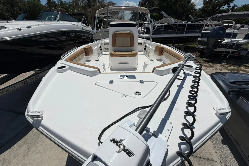 Slide: The Image of 2024 NauticStar 211 Hybrid boat with spacious deck and seating, docked outdoors. - 2