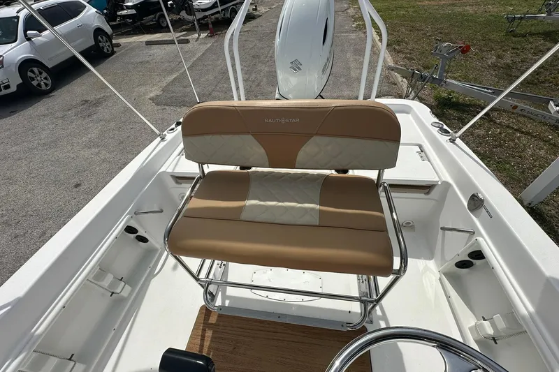 Slide: The Image of 2024 NauticStar 211 Hybrid boat interior with tan seating and steering wheel. - 16