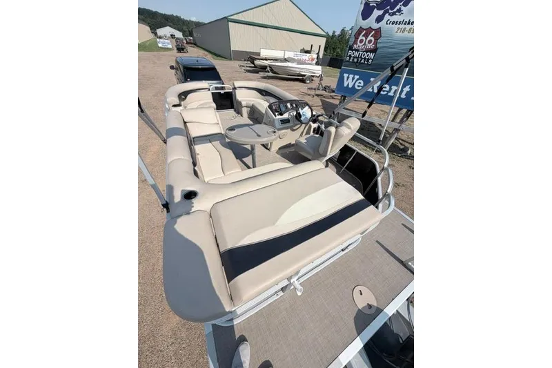 Slide: The Image of 2016 Bennington SX 20 pontoon boat with beige seating and steering console. - 20
