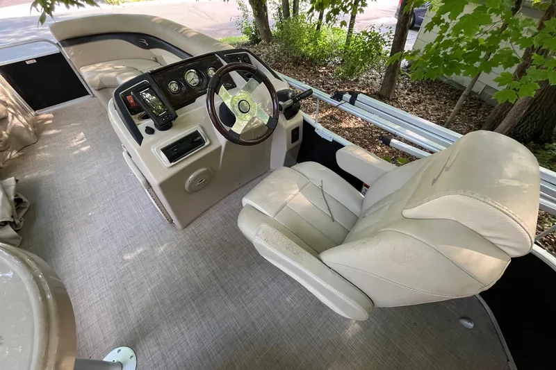 Slide: The Image of 2016 Bennington SX 20 boat interior with beige captain's chair and control panel. - 13