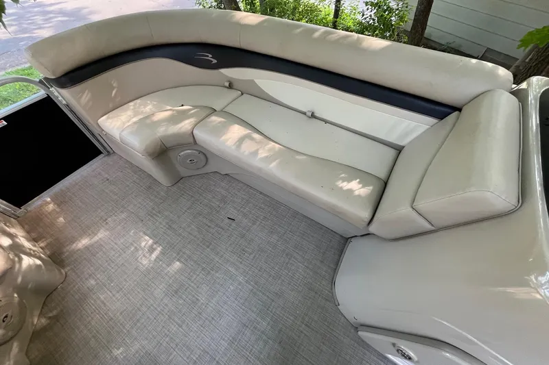 Slide: The Image of 2016 Bennington SX 20 boat interior with beige seating and carpeted flooring. - 16