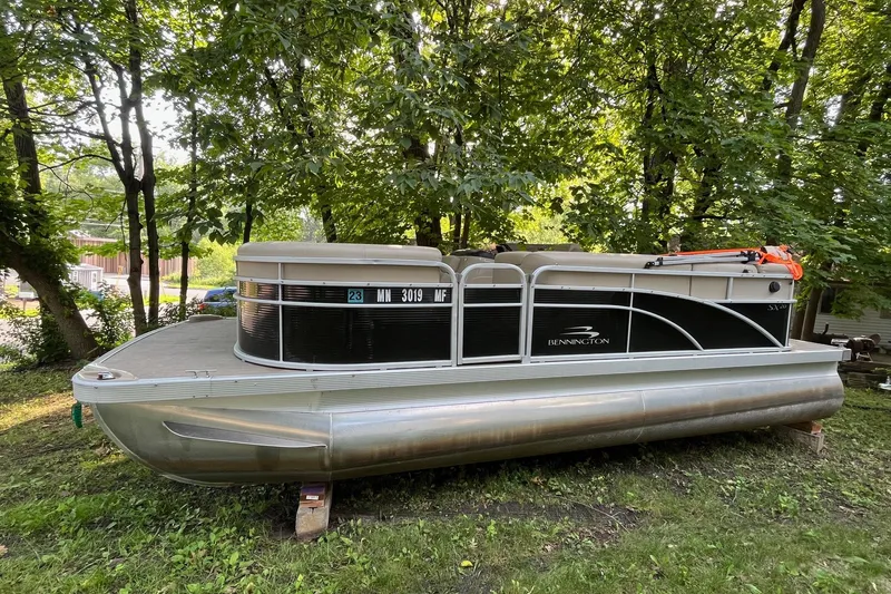 Slide: The Image of 2016 Bennington SX 20 pontoon boat on grass, surrounded by trees. - 7