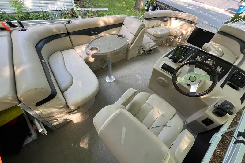 Slide: The Image of 2016 Bennington SX 20 pontoon boat interior with beige seating and steering console. - 9