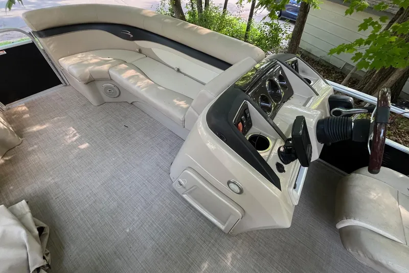 Slide: The Image of Interior of a 2016 Bennington SX 20 pontoon boat with beige seating and control console. - 11
