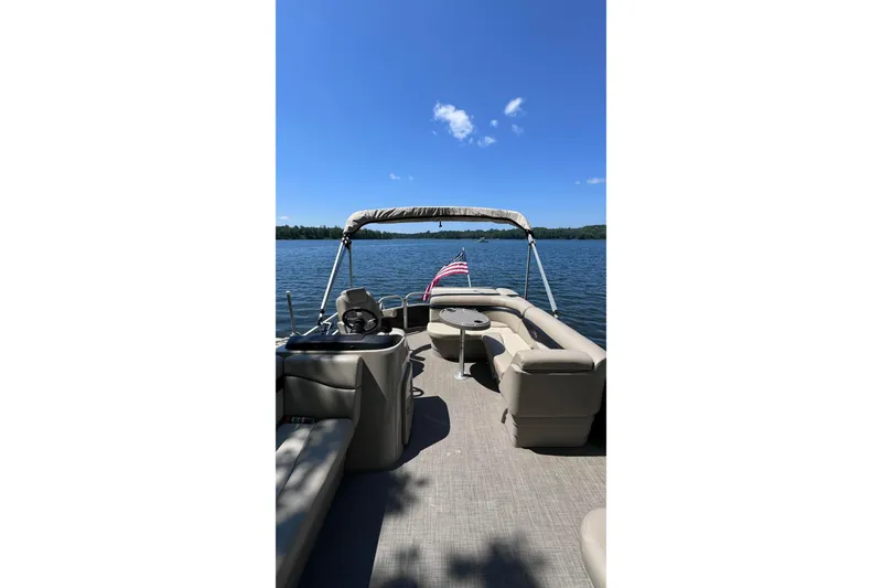 Slide: The Image of 2016 Bennington SX 20 pontoon boat on a serene lake under a clear blue sky. - 6