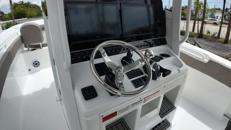 Slide: The Image of The image shows the helm of a Sea Hunt Gamefish 30 with dual large screens and a shiny steering wheel. - 28