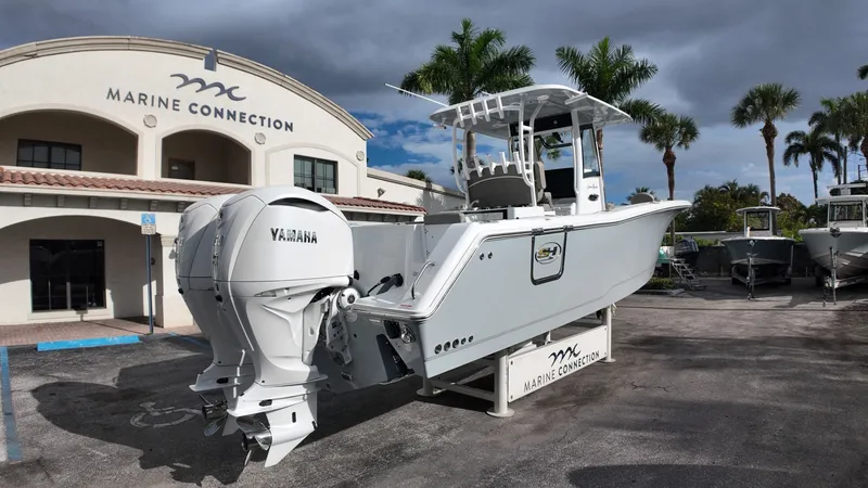Slide: The Image of 2026 Sea Hunt Gamefish 30 in front of a building with palm trees. - 4