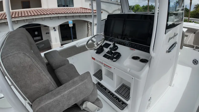 Slide: The Image of The image shows the cockpit of a Sea Hunt Gamefish 30 Forward Seating boat with gray seats and modern electronics. - 16
