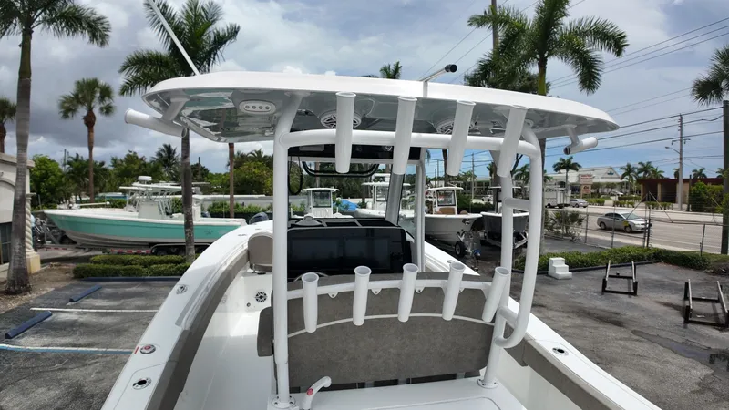 Slide: The Image of A modern boat with T-top and fishing rod holders, surrounded by palm trees and other boats. - 25
