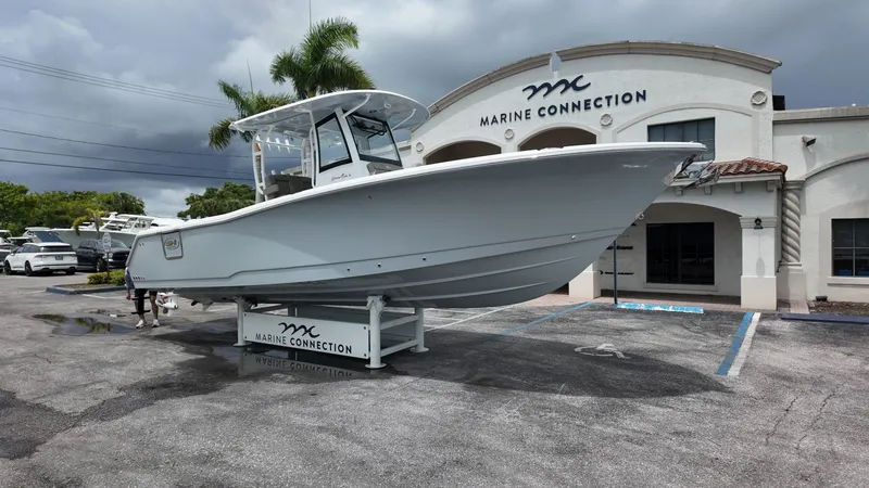 Slide: The Image of A Sea Hunt Gamefish 30 Forward Seating boat on a trailer in front of a building. - 2