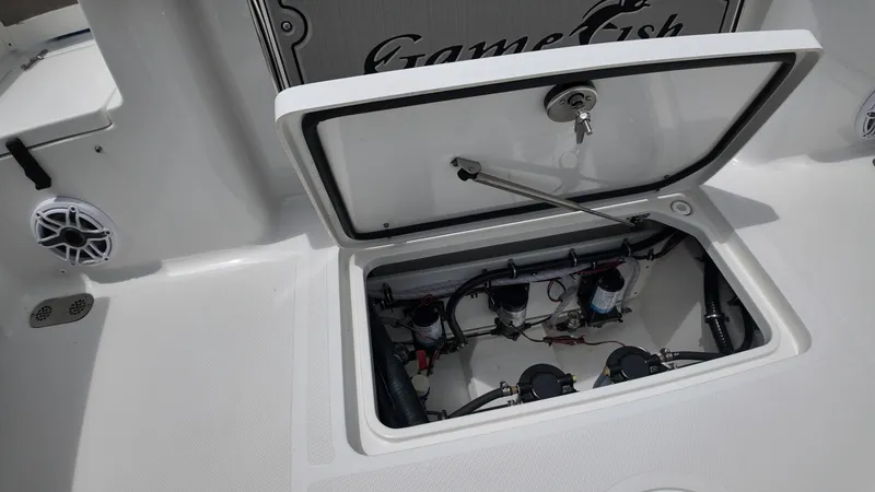 Slide: The Image of An open storage compartment on a Sea Hunt Gamefish 30 boat reveals technical components. - 20