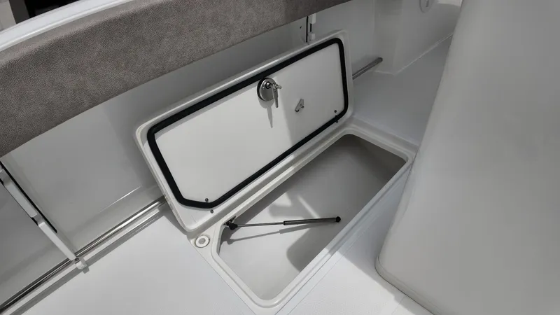 Slide: The Image of An open storage compartment on a boat with gray upholstery and white flooring. - 18