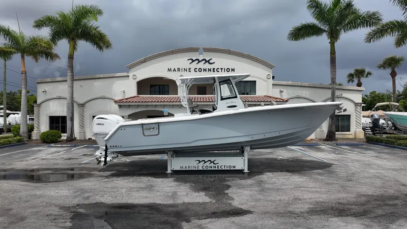The Image of A Sea Hunt Gamefish 30 Forward Seating boat is parked in front of a building with palm trees. - 1