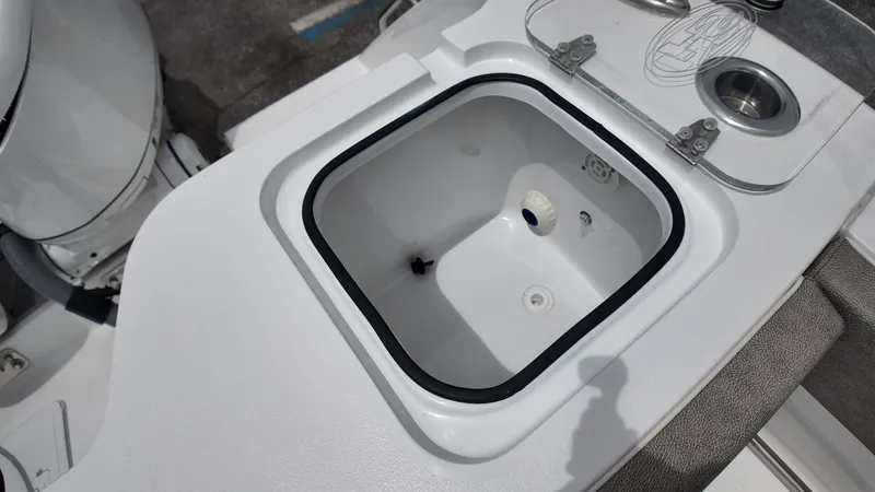 Slide: The Image of An open storage compartment on a boat with a cushioned seating area beside it. - 15