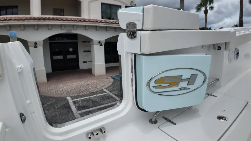 Slide: The Image of A boat with a white seat and a blue compartment featuring the "SH" logo. - 22