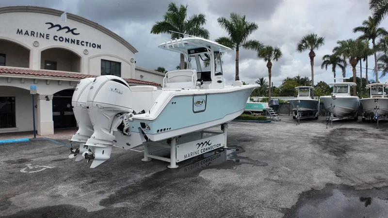 Slide: The Image of A Sea Hunt Ultra 265 SE boat on a trailer in front of a building with palm trees. - 5