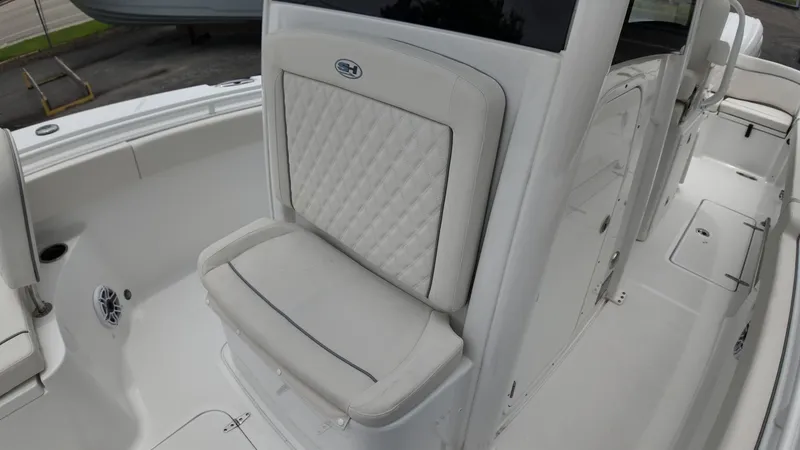 Slide: The Image of The image shows the interior of a 2027 Sea Hunt Ultra 265 SE boat with cushioned seating. - 45