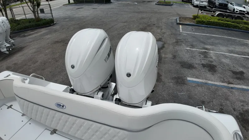 Slide: The Image of Two large outboard engines are mounted on the stern of a boat parked in a lot. - 11