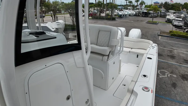 Slide: The Image of The image shows the cockpit of a Sea Hunt Ultra 265 SE boat. It features white upholstery and modern amenities. - 47
