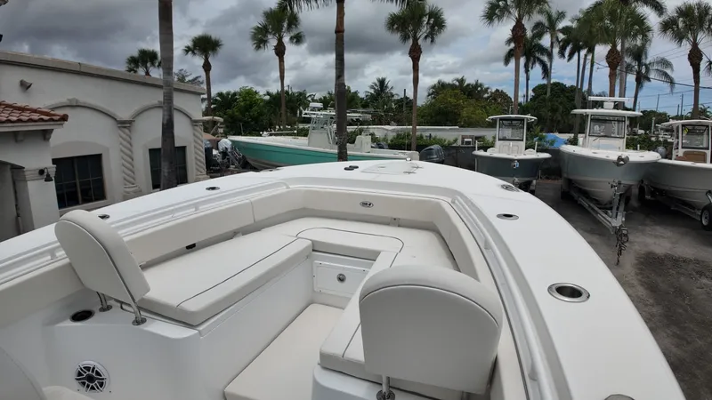 Slide: The Image of The image shows the deck of a 2027 Sea Hunt Ultra 265 SE boat, surrounded by palm trees. - 41